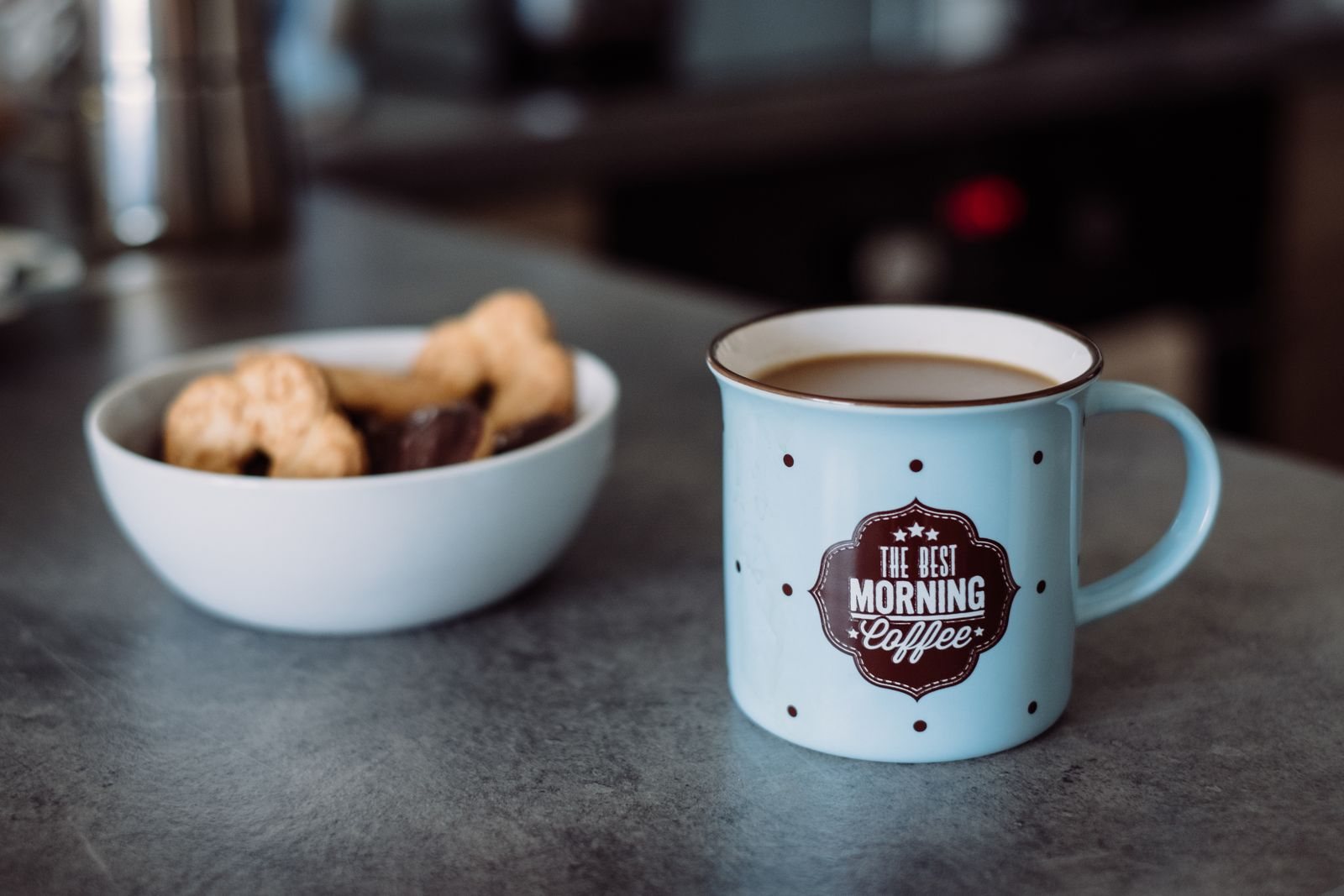 A bowl and a cup of coffee on a worktop, in the morning